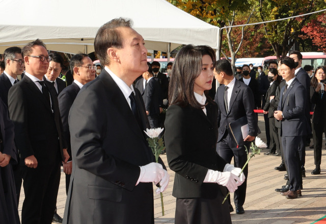 윤석열 대통령과 부인 김건희 여사가 31일 오전 서울광장에 마련된 이태원 사고 사망자 합동분향소를 방문, 헌화를 위해 이동하고 있다. 연합뉴스