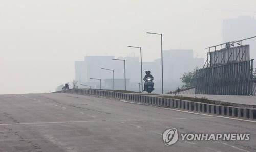 1일 뉴델리의 대기오염 속을 달리는 오토바이. [EPA 연합뉴스 자료사진. 재판매 및 DB 금지]