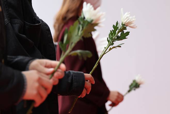 People place flowers at a memorial altar in front of City Hall in Seoul on Thursday. (Yonhap)