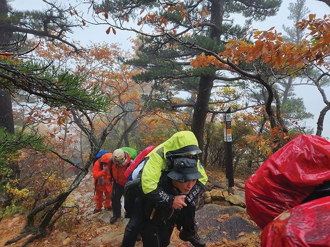 80세 A씨를 업고 오세암으로 향하는 구조대원들.