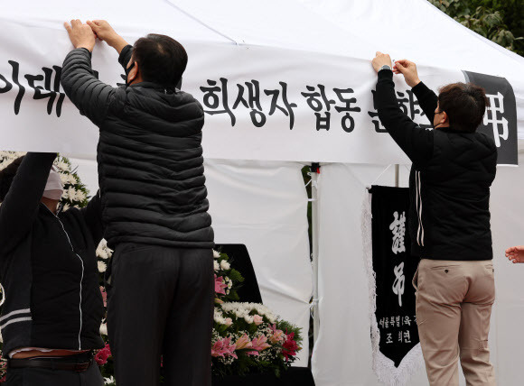 3일 오후 서울 종로구 서울특별시교육청 옆에 마련된 합동 분향소에서 교육청 직원들이 ‘이태원 사고 사망자 합동분향소’가 적힌 현수막을 ‘이태원 참사 희생자 합동분향소’로 교체하고 있다. 뉴스1