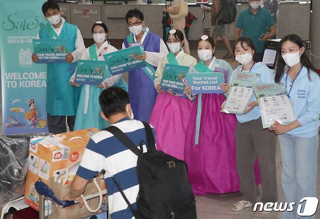 부산관광공사 직원들과 한국방문위원회 직원들이 지난 8월16일 부산 강서구 김해국제공항 국제선청사에서 정부의 특별시행에 따라 지난 4일부터 8월 한 달간 무비자 입국이 허용된 일본인 관광객들을 맞이하고 있다. 2022.8.16/뉴스1 ⓒ News1 김영훈 기자