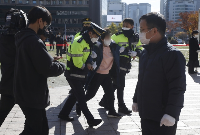 4일 서울광장에 마련된 이태원 참사 희생자 합동분향소에서 한 유족이 윤석열 대통령과 오세훈 서울시장의 근조화환을 내동댕이치고 대통령과 행안부 장관의 사죄를 촉구하며 분노하다 경찰에 의해 끌려 나가고 있다. 뉴시스