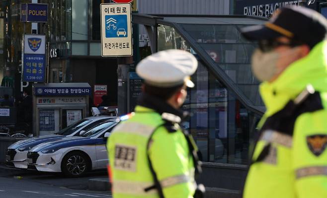 4일 오전 서울 용산구 이태원역 1번 출구 앞 참사 추모 공간에서 보이는 이태원 파출소와 근무 중인 경찰들. 연합뉴스