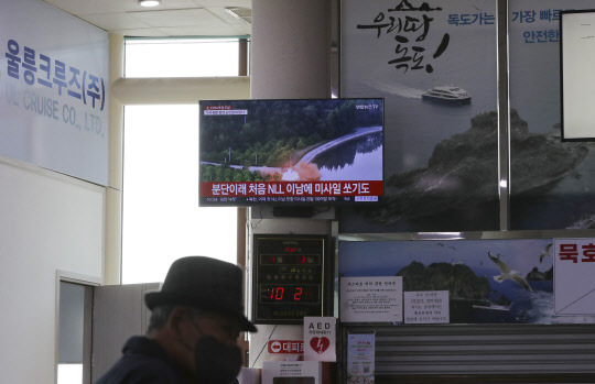 3일 경북 울릉군 울릉읍 사동항 여객선터미널에 설치된 TV로 북한 미사일 관련 뉴스가 나오는 가운데 여행객이 TV 앞을 지나가고 있다. 이날도 북한이 동해상으로 탄도미사일을 발사했다고 합동참모본부가 밝혔다. [연합뉴스]