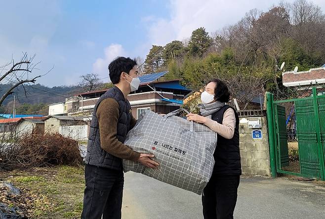 [보은=뉴시스] 안성수 기자 = 충북 보은군 노인·장애인복지관 '꿈 나르는 빨래방'에 참여한 사회복지사가 5일 지역 노인에게 세탁한 겨울 이불을 건내주고 있다. (사진=보은군 제공) 2022.11.05 photo@newsis.com *재판매 및 DB 금지