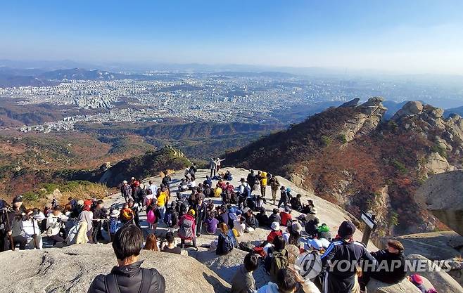 늦가을, 북한산 산행 인파 (서울=연합뉴스) 11월의 첫 주말인 6일 서울 강북구 북한산 백운대에서 시민들이 서울 전경을 감상하고 있다. 2022.11.6 [북한산국립공원 산악안전봉사단 제공. 재판매 및 DB 금지] photo@yna.co.kr