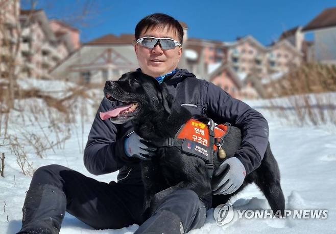 인명 구조견 '마루'와 최헌 소방장 (춘천=연합뉴스) 험준한 강원도 산악지역을 7년 가까이 누비며 179회 출동해 생존자 6명을 구조하는 등 활약한 강원도소방본부 소속 인명구조견인 수컷 래브라도 리트리버 마루(10)가 오는 10일 양양항공대 격납고에서 은퇴한다.
    사진은 마루와 핸들러 최헌(47) 소방장이 눈밭에서 휴식을 취하고 있는 모습. 2022.11.9 [최헌 소방장 제공. 재판매 및 DB 금지] taetae@yna.co.kr