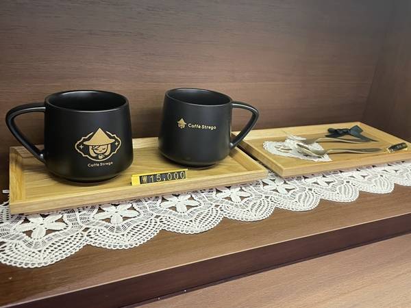 - 카페 스트레가의 로고가 그려진 머그컵과 커틀러리