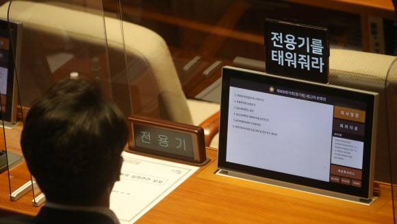 전용기 더불어민주당 의원이 10일 서울 여의도 국회에서 열린 본회의에서 대통령실의 MBC 취재진 대통령 전용기 탑승 불허와 관련해 자신의 휴대전화 화면에 ‘전용기를 태워줘라’고 적어놓은 메시지를 걸어놓고 있다. 2022.11.10. 뉴시스