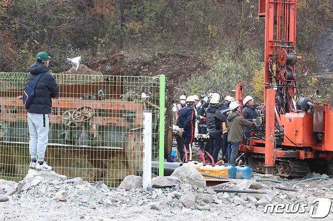 3일 오전 경북 봉화군 아연광산 매몰 사고 현장에서 한국광해광업공단 등 구조반 관계자들이 천공기를 이용해 확보한 지하 170m 지점에 내시경을 넣어 고립 작업자들의 생존 여부를 확인하고 있다. 뒤편에서 가족들이 구조작업을 애타게 지켜보고 있다. 2022.11.3/뉴스1 ⓒ News1 공정식 기자