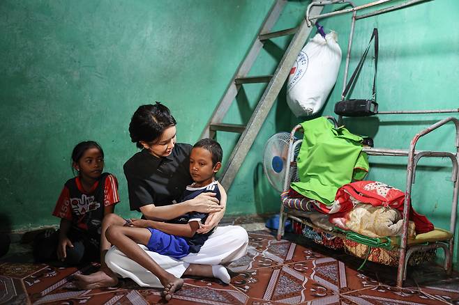 윤석열 대통령 부인 김건희 여사가 12일 캄보디아 프놈펜에서 선천성 심장질환을 앓고 있는 14세 아동의 집을 찾아 아이를 안고 있다. /뉴스1
