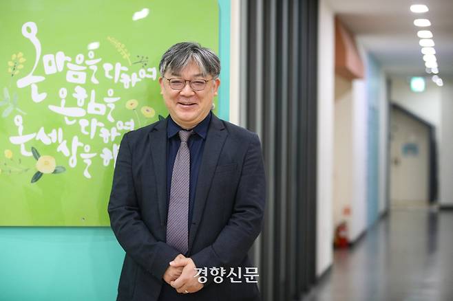 김현수 안산온마음센터장이 경향신문과 인터뷰를 한 뒤 자신이 직접 작성한 문구로 만든 캘리그라피 액자를 소개하며 포즈를 취하고 있다. 성동훈 기자