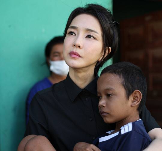 윤석열 대통령 부인 김건희 여사가 지난 12일(현지시간) 캄보디아 프놈펜에서 선천성 심장질환을 앓고 있는 14세 아동의 집을 찾아 건강상태를 살피고 위로하고 있다. 대통령실 제공