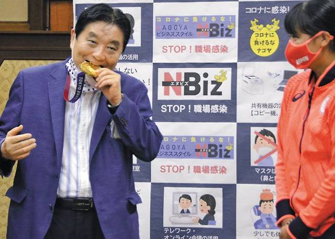 가와무라 다카시(왼쪽) 나고야 시장이 지난 4일 시청을 방문한 도쿄올림픽 소프트볼 우승 멤버 고토 미우의 금메달을 깨물고 있다. /교도 연합뉴스