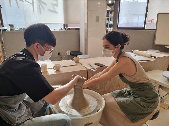 A student centers clay on a pottery wheel at Anna Pottery in Gwangjin-gu, Seoul. (Anna Pottery)