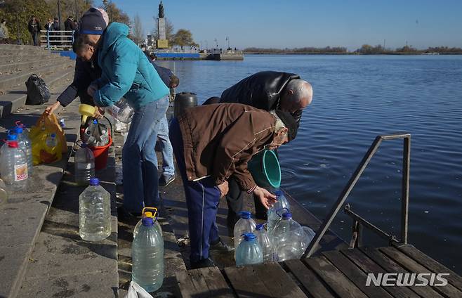 [헤르손=AP/뉴시스] 15일(현지시간) 우크라이나 헤르손 주민들이 드니프로강에서 물을 긷고 있다. 2022.11.16.