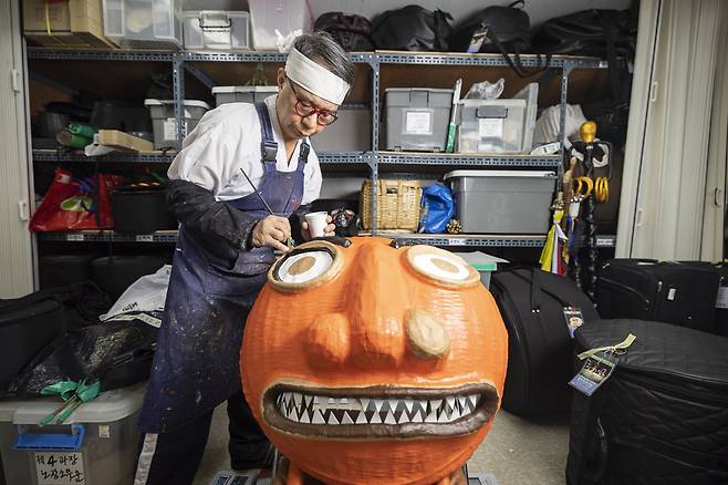 정윤식 봉산탈춤 이수자가 11일 오후 서울 봉산탈춘보존회 작업실에서 사자탈을 만드는 작업을 하고 있다. 정 이수자 뒤로 공연 소품들이 보인다.