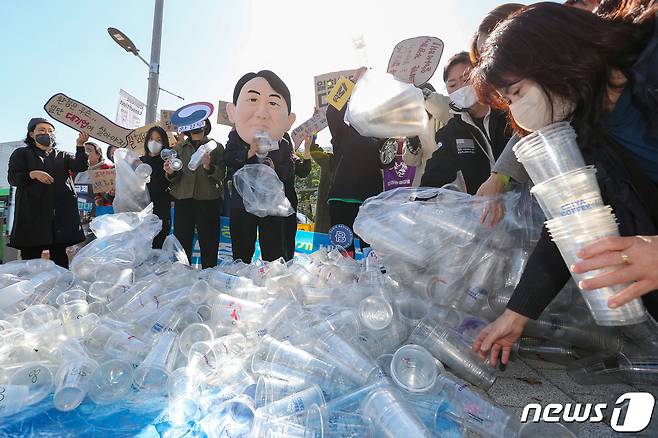 서울환경연합 관계자들이 10월18일 오전 서울 용산구 전쟁기념관 앞에서 열린 '일회용 컵 보증금제 무력화하는 윤석열 정부 규탄 기자회견'에서 일회용 컵 보증금제 시행을 촉구하는 퍼포먼스를 하고 있다. 서울환경연합은 이날 "2020년 자원재활용법 개정 이후 무려 2년의 준비기간이 있었으나 환경부의 악의적인 직무유기로 일회용 컵 보증금제도는 시행도 되기 전에 일방적으로 연기되고 대폭 축소됐다＂고 주장했다. 2022.10.18/뉴스1 ⓒ News1 민경석 기자