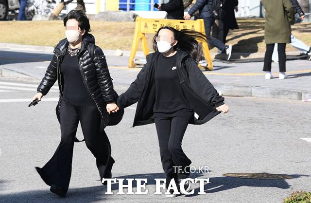 논술시험을 마친 수험생이 다른 학교의 시험을 치르기 위해 어머니와 함께 교정을 달려 나가고 있다.