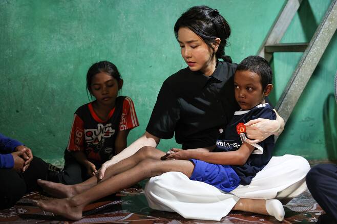 윤석열 대통령 부인 김건희 여사가 12일 캄보디아 프놈펜에서 선천성 심장질환을 앓고 있는 14세 아동의 집을 찾아 아이를 안고 있다. /뉴스1