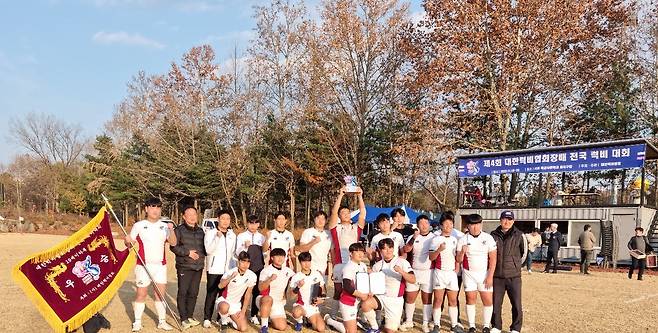 고양 백신고 럭비부 선수들이 20일 서울 육사에서 열린 제4회 대한럭비협회장배 전국 럭비대회에서 우승컵 및 우승기를 들고 기념사진을 찍고 있다. 백신고 제공.