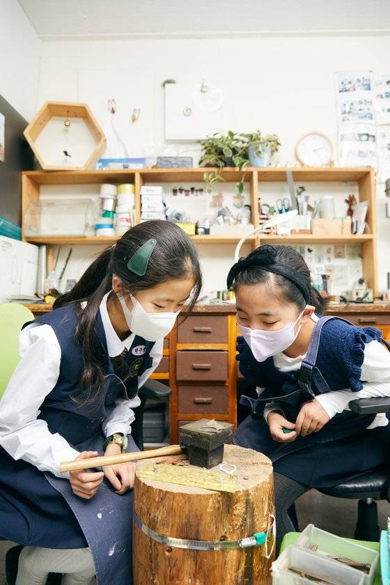 모루에 금속판을 올리고, 망치로 내리쳐 이니셜 도장 찍기를 연습한 소중 학생기자단. 이니셜 도장이 잘 찍히기 위해선 힘 조절이 중요하다.