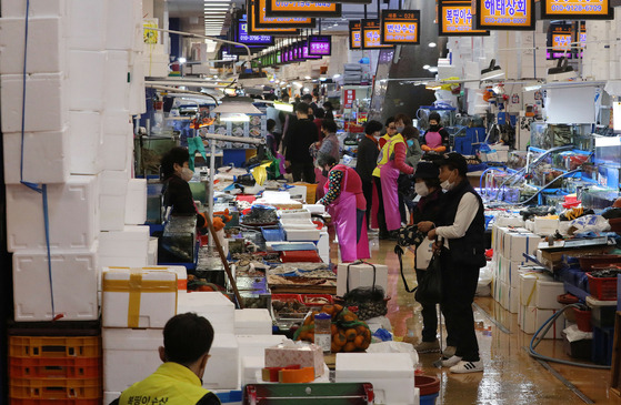 Fresh food products from traditional markets in Seoul will be available through dawn delivery services. The Seoul Metropolitan Government said Monday that micro fulfillment centers and digital logistics platforms will be implemented at the Cheongnyangni Traditional Market, Amsa Complex Market and Noryangjin Fish Market for fast deliveries. Deliveries will be made across the city of Seoul and in areas in Gyeonggi. Above, people shop for groceries at Noryangjin Fish Market on Monday. [NEWS1]