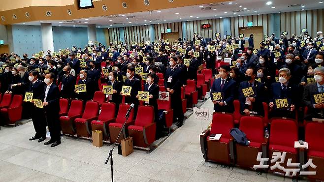 한국기독교교회협의회가 21일 오후 서울 강북구 한신대 신대원 채플실에서 제71회 정기총회를 열었다. 참석자들이 '평화를 원한다'는 내용의 피켓을 들고 기념사진을 찍고 있다.