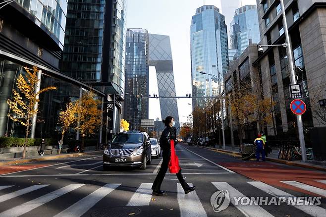 코로나19 재확산으로 인적 드문 베이징 차오양구 (베이징 로이터=연합뉴스) 코로나19가 재확산하는 중국 베이징 중심지 차오양구에서 21일 한 시민이 오전 러시아워임에도 한산한 거리를 가로지르고 있다. 이날 중국 방역당국에 따르면 전날 중국 본토 신규감염자는 2만6천301명으로 집계됐다. 최근 코로나19가 급속히 번진 베이징의 신규 감염자는 951명이다. 2022.11.21 alo95@yna.co.kr