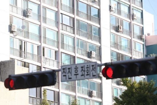 한국은행이 기준금리를 0.5% 포인트 올리면서 부동산 거래시장의 빙하기가 장기화될 것으로 보인다. 13일 서울 시내 한 아파트 인근 신호등에 빨간불이 켜져 있다.