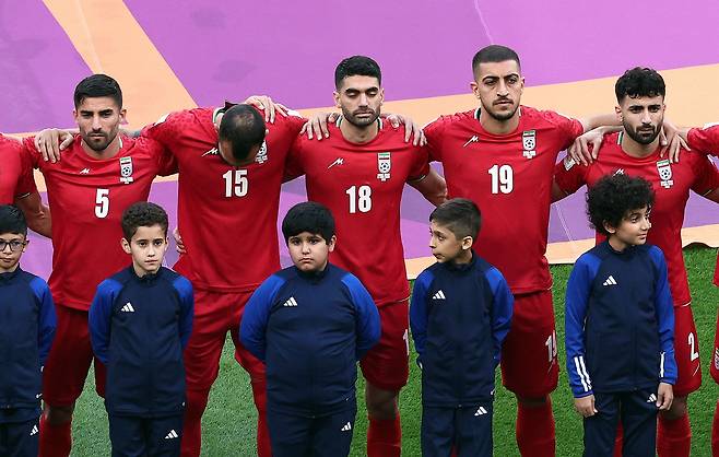 이란 축구 국가대표팀 선수들이 국가 제창을 거부하고 굳은 표정으로 서 있다. /로이터 뉴스1