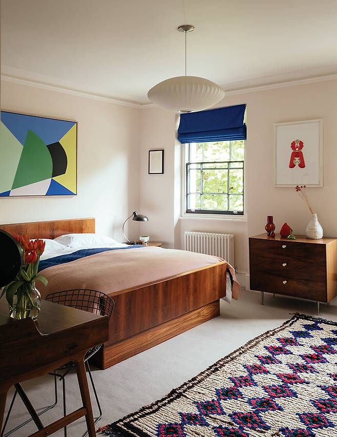 아름다운 패턴의 수아드 라루시 러그로 포근함을 더한 안방은 꼭대기 층에 자리하고 있다. 목재 침대와 화장대, 책상 모두 빈티지 제품. 천장에 달린 펜던트 조명 ‘버블(Bubble)’은 조지 넬슨이 디자인한 헤르만 밀러 제품이다.