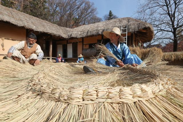 21일 경기 용인시 한국민속촌에서 관계자들이 월동준비로 이엉잇기를 시연하고 있다. 용인=연합뉴스