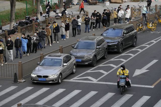 베이징 주민들이 21일 코로나19 검사를 받기 위해 줄을 서 있다. AP연합