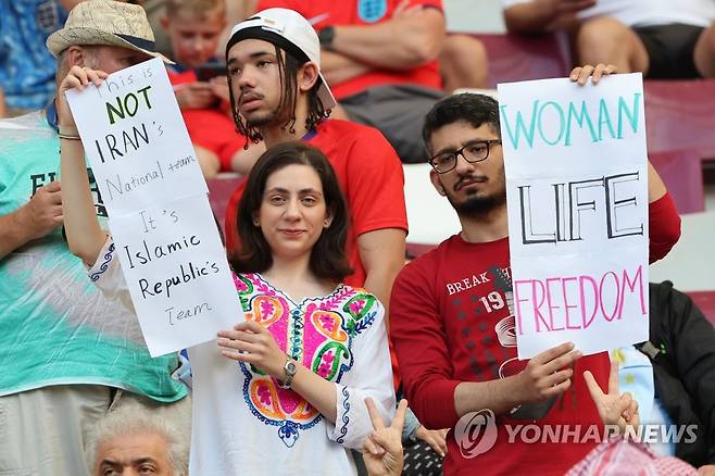 여성의 자유 강조하는 축구팬 (도하=연합뉴스) 김주성 기자 = 21일 오후(현지시간) 카타르 도하의 칼리파 인터내셔널 스타디움에서 열린 2022 카타르 월드컵 조별리그 B조 1차전 잉글랜드 대 이란 경기에서 관중이 여성의 자유를 보장할 것을 호소하는  피켓을 들고 있다.  2022.11.22 utzza@yna.co.kr