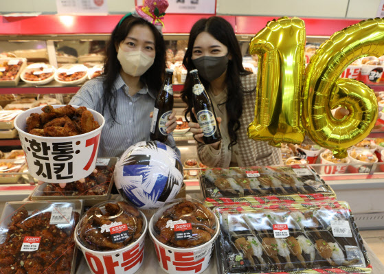 롯데마트 모델들이 서울역점 델리코너에서 ‘먹거리 행사 상품’을 홍보하고 있다.(사진=롯데마트)