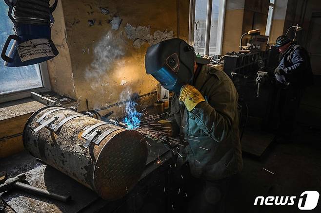 8일(현지시간) 우크라이나 르비우에서 근로자가 병사와 주민들을 위해 장작 난로를 만들고 있다. ⓒ AFP=뉴스1 ⓒ News1 우동명 기자