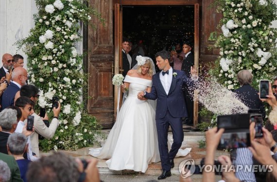 epa10142092 Retired Italian swimmer Federica Pellegrini (L) is accompanied by her husband Matteo Giunta (R) as they leave the church of San Zaccaria, where she married her coach, in Venice, Italy, 27 August 2022. Federica Pellegrini won a gold medal at the 2008 Beijing Olympics and hold various World Champion titles. EPA/ANDREA MEROLA /사진=연합뉴스