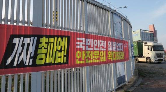 민주노총 공공운수노조 화물연대 총파업을 하루 앞둔 23일 오전 인천 연수구 인천신항 컨테이너 터미널 앞에 총파업과 관련된 문구가 적힌 현수막이 걸려있다. 민주노총 공공운수노조 화물연대본부는 오는 24일 0시부터 무기한 전면 집단운송거부 예고했다. 안전운임제가 현장에서 여전히 정착되지 않고 있다며 5개월 만에 다시 운송 거부에 나섰다. 사진=뉴시스