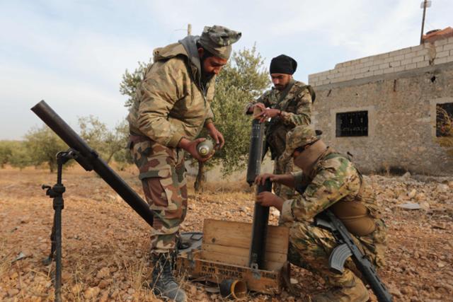 튀르키예가 지원하는 시리아군들이 21일(현지시간) 튀르키예 국경과 인접한 자라불루스 지역에서 박격포를 조립하고 있다. 자라불루스=AFP·연합뉴스