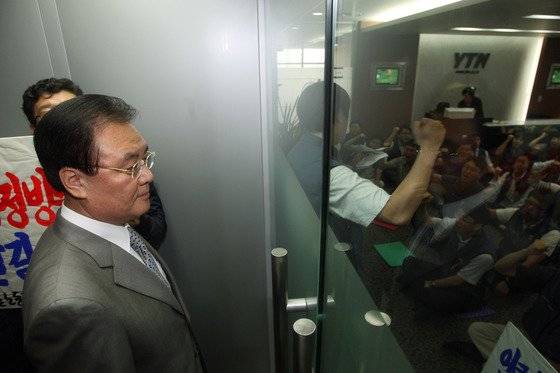 2008년 9월 8일 이명박 대통령의 측근인 구본홍 특보가 YTN 신임사장으로 임명되자 노조원들이 사장실로 통하는 출입문을 잠그고 출근저지 시위를 하고 있다. 문 밖에 서 있는 구본홍 사장.