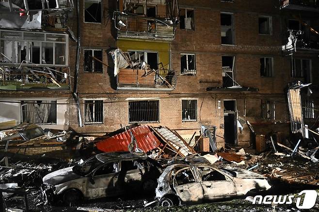 23일(현지시간) 우크라이나 키이우 인근 비슈고르드에서 러시아 군의 포격을 받아 부서진 주거 건물과 불에 탄 차량이 보인다. ⓒ AFP=뉴스1 ⓒ News1 우동명 기자