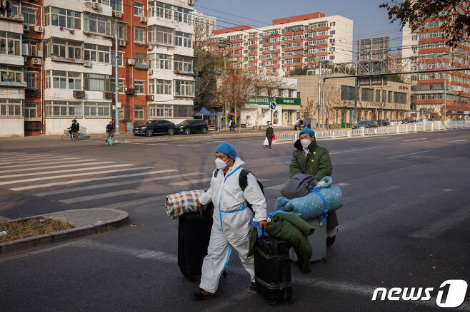 23일 중국 베이징에서 신종 코로나바이러 감염증(코로나19)가 확산함에 따라 방역 위생 관계자들이 짐을 들고 출근하고 있는 모습. 2022.11.23/뉴스1 ⓒ 로이터=뉴스1 ⓒ News1 김민수 기자