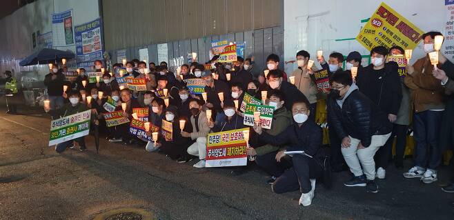한국주식투자자연합회 회원들이 13일 서울 여의도 민주당사 앞에서 금융투자소득세 도입에 반대하는 촛불 시위를 갖고 있다. /뉴스1