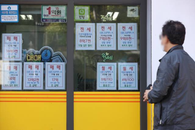 한 시민이 서울 시내 공인중개사사무소 앞을 지나고 있다. 연합뉴스