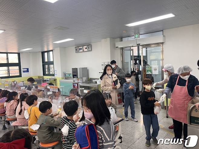 25일 오전 11시 40분쯤 강원 춘천시 석사동의 한 초등학교 급식실에서 초등학생들이 빵과 음료가 담긴 봉투를 받고 있다.2022.11.25 한귀섭 기자