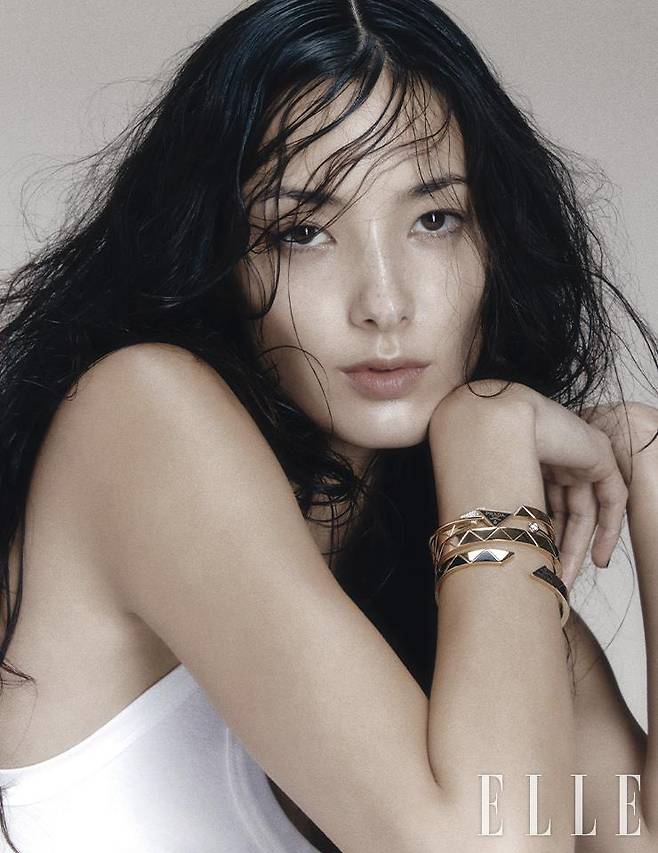 삼각 로고에 51개의 라운드 브릴리언트 컷 다이아몬드를 세팅한 옐로골드 브레이슬렛, 블랙 에나멜 로고와 라운드 브릴리언트 컷 다이아몬드를 세팅한 옐로골드 브레이슬렛, 트라이앵글 패턴의 옐로골드 브레이슬렛, 블랙 세라믹으로 삼각 패턴을 표현한 옐로골드 브레이슬렛은 모두 Prada Fine Jewelry. 화이트 코튼 슬리브리스 드레스는 Prada.