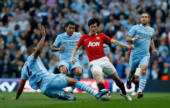 2012년 맨체스터 에티하드 경기장에서 열린 잉글랜드 프리미어리그 맨체스터 시티와 맨체스터 유나이티드의 축구 경기에서 맨유의 박지성(오른쪽 둘째)이 돌파를 시도하다 맨시티 수비진의 태클에 걸려 중심을 잃고 있다. [사진 = AP연합뉴스]