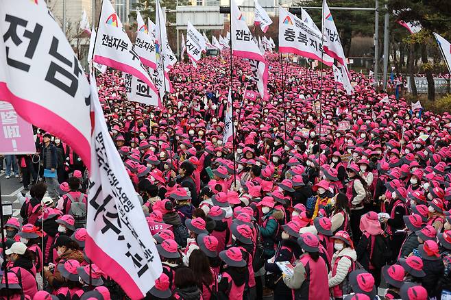 전국학교비정규직노동조합 조합원들이 25일 오후 서울 영등포구 국회 앞에 모여 있다. 이들은 정규직과의 임금 차별 해소와 급식실 폐암 종합대책 마련, 교육교부금 축소 반대 등을 주장했다. [연합]